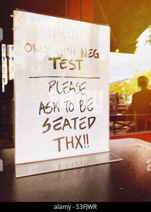 Firma presso un Burger Restaurant a Berlino che dichiara che saranno serviti solo i clienti con Corona Test negativi e devono chiedere di essere seduti, Berlino, Germania Foto Stock