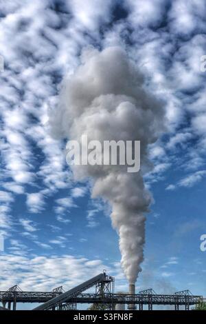 Fumo che sale da camino industriale Foto Stock