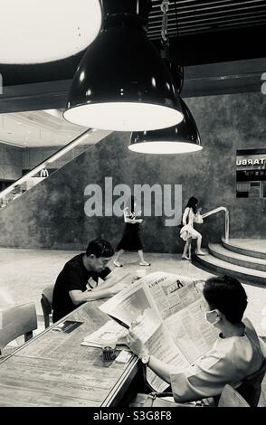 Leggere il giornale del mattino a Hong Kong. Foto Stock