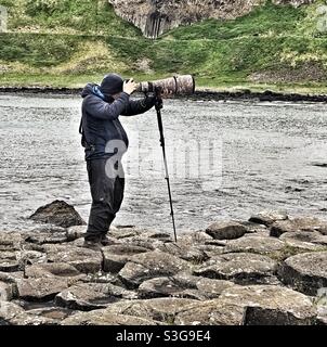 Fotografo al Giants Causeway nell'Irlanda del Nord Foto Stock