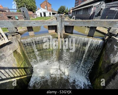 Fuoriuscita di acqua su una serie di cancelli di blocco sul canale Shropshire Union Foto Stock