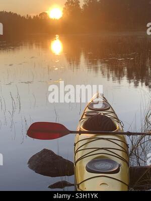 Kayak giallo sul lago calmo nella notte estiva. Bergslagen, Svezia. Foto Stock