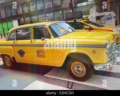 Un taxi d'epoca Checker parcheggiato accanto ad un nuovo taxi nel centro di Manhattan, 2021, NYC, USA Foto Stock