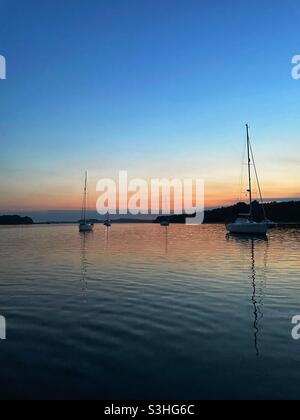 Crepuscolo e calmo serale ad un ancoraggio a Poole Harbour sulla costa meridionale dell'Inghilterra Foto Stock