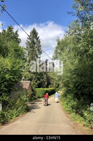 Una coppia anziana cammina lungo una corsia di campagna in Oxfordshire, Regno Unito Foto Stock