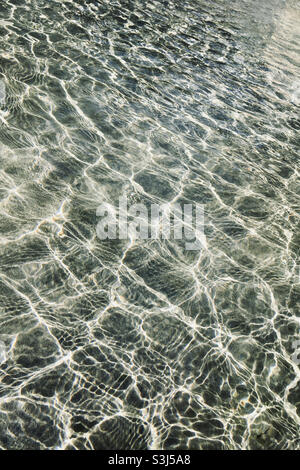 Onde d'acqua in piscina con luce del sole che scintillano sulla superficie Foto Stock