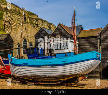 La nave da pesca Grace Georgina blu e bianca di fronte alle capanne da pesca e al museo del pescatore nella città vecchia di Hastings Regno Unito Foto Stock