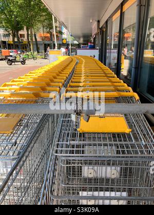 Carrelli per lo shopping allineati di fronte al negozio Foto Stock