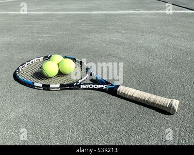 Palle da tennis giacenti nella racchetta da tennis con blu e bianco. Foto Stock