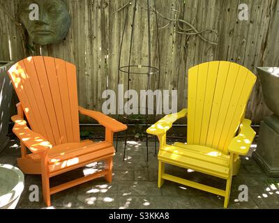 Un paio di sedie colorate in stile Adirondack, che si trovano all'interno dell'ingresso esterno di un negozio di giardinaggio locale a Salt Lake City, Utah, USA. Foto Stock