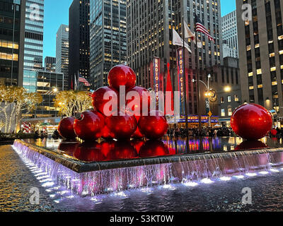 Durante la stagione natalizia, gli ornamenti giganti dell'albero di Natale sono impilati in alto e riflettono la piscina di fronte alla radio City Music Hall, New York City, Stati Uniti, 2021 Foto Stock