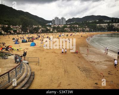 I turisti nazionali visitano la spiaggia artificiale di Tai Pak di Discovery Bay, l'isola di Lantau, Hong Kong Foto Stock