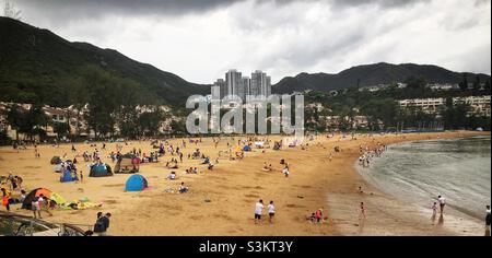 I turisti nazionali visitano la spiaggia artificiale di Tai Pak di Discovery Bay, l'isola di Lantau, Hong Kong Foto Stock