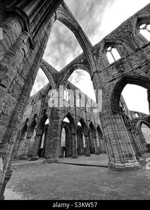 Una fotografia all'interno dell'Abbazia di Tintern, in bianco e nero, della struttura e dell'architettura delle rovine Foto Stock