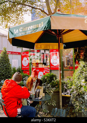 Interessante giovane coppia che pranza al Villaggio invernale Bank of America a Bryant Park, 2021, New York City, USA Foto Stock