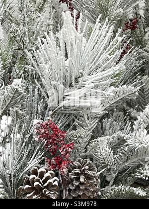 Le composizioni floreali artificiali di Natale sono vendute presso un Walmart locale nello Utah, Stati Uniti. Molto stagionale con aghi di pino verde, bacche rosse e floccaggio per dare un aspetto glassato. Foto Stock