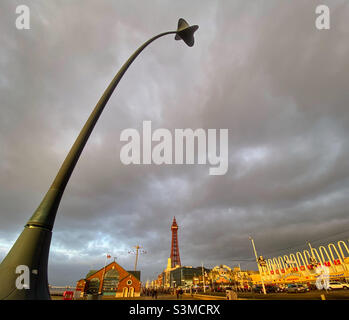 Blackpool Golden Mile incorniciato da una scultura in erba di mare piegata dal vento con Blackpool Tower in lontananza Foto Stock