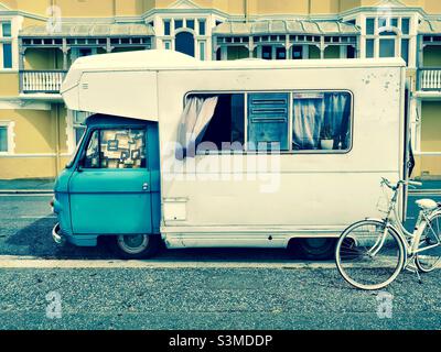 camper vintage parcheggiato sulla strada della città con la bicicletta Foto Stock