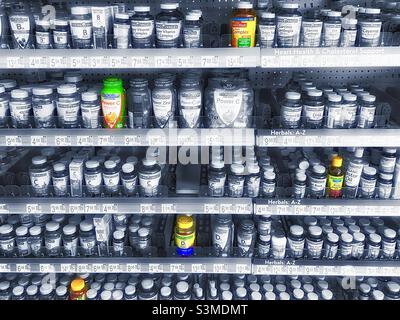 Vitamine, minerali e supplementi sugli scaffali di un Walmart locale in Utah, Stati Uniti. La maggior parte dei prodotti sono in bianco e nero tonalità argento, ma il colore selezionato è stato utilizzato anche per l'effetto artistico. Foto Stock