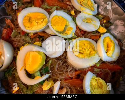 Tagliatelle di verdure di pollo saltate in casa, condimenti con fetta di uova bollite. Foto Stock