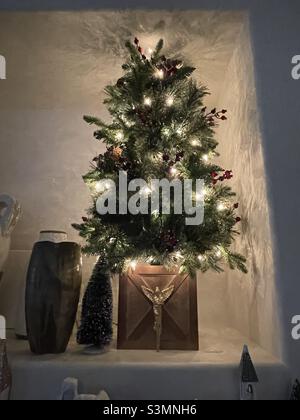 L'arredamento stagionale della casa decora una casa durante la stagione di Natale intorno al camino e il focolare, rendendo un accogliente, allegro e caldo spazio di vita. Foto Stock