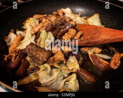 Pollo saltato con melanzane e cavolo taiwanese su una padella. Foto Stock