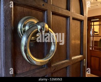 Un primo piano della porta d'ingresso con un brillante bussare d'argento di un hotel di campagna Rutland Foto Stock