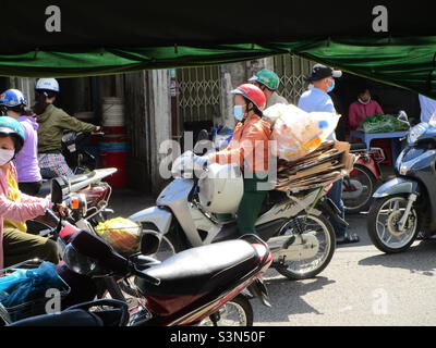 Polizia di strada (in camicia blu) ispezionare negozi di fiori su le Van Phan Street, Phu Thuy, Phan Thiet, Binh Thuan, Vietnam (29 gennaio 2022 alle 11h35) Foto Stock