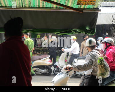 Polizia (in camicia verde) ispezionare negozi di fiori su le Van Phan Street, Phu Thuy, Phan Thiet, Binh Thuan, Vietnam (29 gennaio 2022 alle 11h35) Foto Stock