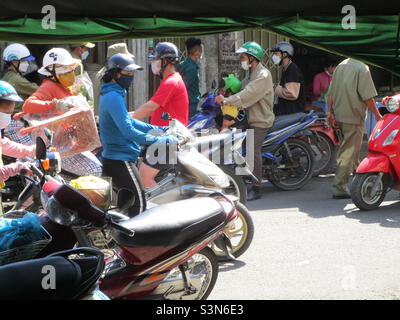 Polizia (in camicia verde) ispezionare negozi di fiori su le Van Phan Street, Phu Thuy, Phan Thiet, Binh Thuan, Vietnam (29 gennaio 2022 alle 11h35) Foto Stock