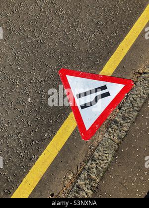 Segnale stradale, strada stretta sulla destra, in discesa sul marciapiede Foto Stock