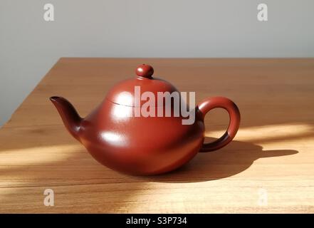 Teiera Yixing Zisha artigianale realizzata in argilla rossa viola a forma di pera, che mostra l'intricata arte e la ricca tradizione della cultura cinese del tè Foto Stock