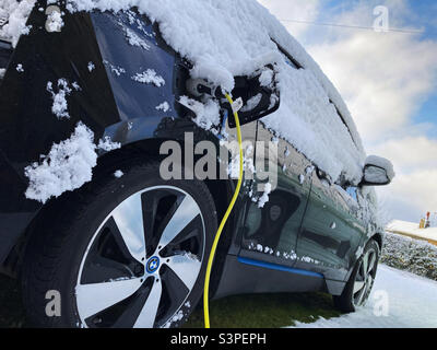 BMW i3 auto elettrica in carica il giorno d'inverno nella neve Foto Stock