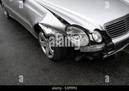 Un'automobile che è stata coinvolta in un incidente stradale con danni ai fari sul parafango anteriore e alla ruota con spazio di riproduzione