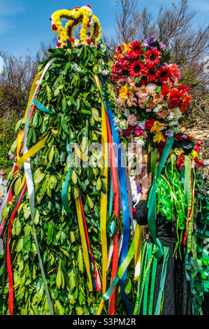 Una donna in costume e con uno staff sormontato da un display floreale, guarda fino al Jack a tradizionali Hastings Jack in the Green festivities. Regno Unito, maggio 2008 Foto Stock