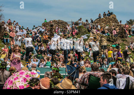 Una grande folla si riunisce all'interno delle mura del castello, guardando una squadra di danza Morris esibirsi sul palco presso le feste tradizionali di Jack in the Green di Hastings. Regno Unito, maggio 2008 Foto Stock