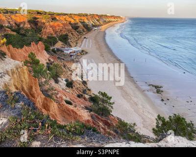 Golden hour colori su una spiaggia di mare con formazioni rocciose di arenaria in Algarve, Portogallo. Foto Stock