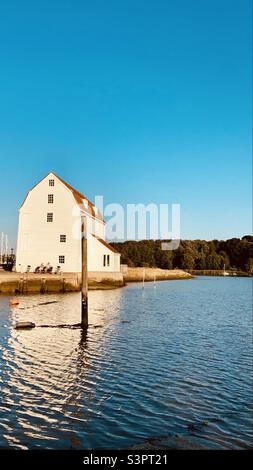 Coppia seduta su una panchina fuori dal pin Mill presso il fiume Deben a Woodbridge, Suffolk, Regno Unito Foto Stock