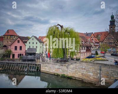 Vecchie case in legno, grandi alberi di salice e diga d'acqua sul fiume Pegnitz a Lauf an der Pegnitz vicino a Norimberga, Germania. Foto Stock