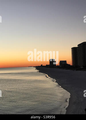 Splendido tramonto sulla spiaggia di Pensacola mentre le onde scivolano sulla sabbia Foto Stock