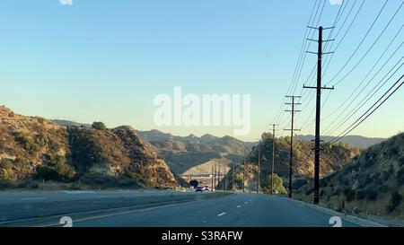 I pali di Telegraph corrono lungo la strada attraverso le montagne a Newhall, Santa Clarita, California Foto Stock