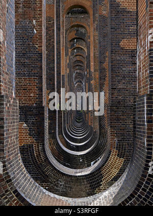 Guardando attraverso gli archi del viadotto ferroviario della Valle dell'Ouse, Balcombe, West Sussex, Inghilterra. Foto Stock