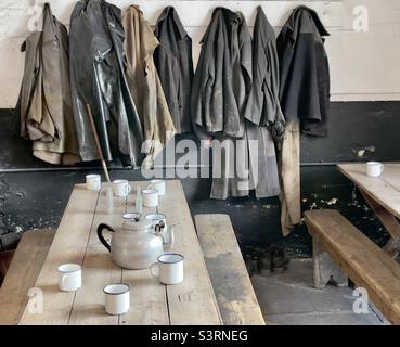 Abbigliamento per minatori di ardesia appeso su pioli nella mensa al National Slate Museum in Galles Foto Stock
