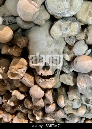 Cranio in una parete di ossa Foto Stock