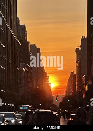 Un brillante tramonto tra gli edifici di New York City Foto Stock