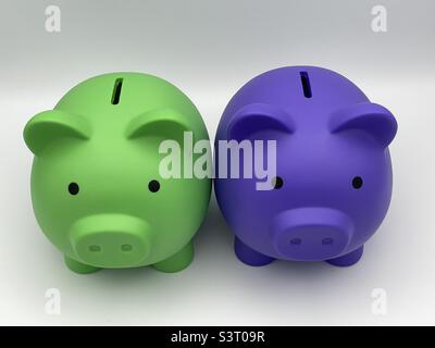 Due banchi di piggy per bambini di colore diverso, viola e verde lime, seduti fianco a fianco. Foto Stock