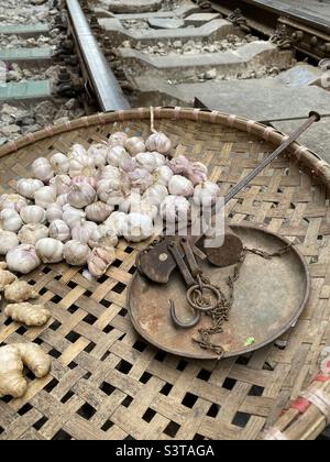 Cestello in tessuto piatto con aglio, zenzero e vecchie scaglie su binari ferroviari. Foto Stock