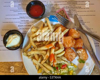 Cibo da pub dell'hotel - pepite di pollo, patatine e insalata Foto Stock