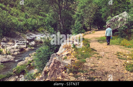 Un uomo cammina lungo il sentiero vicino al fiume a Penedo Furado, Portogallo centrale Foto Stock