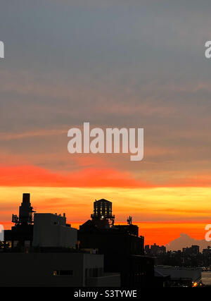 Il tramonto, come osservato da Brooklyn, New York, durante “Manhattanhenge” di martedì 12 luglio 2022. Foto Stock